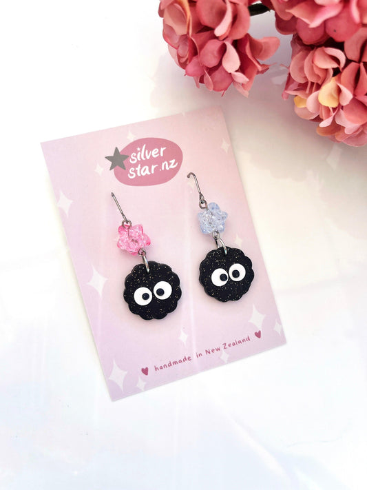Soot Star Polymer Clay Earrings with Bead by silverstar.nz: handmade black soot sprite charms and flower beads, displayed on a pink “silverstar.nz, handmade in New Zealand” card next to pink hydrangeas.